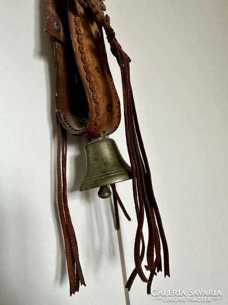 Copper bell with decorative braided leather strap