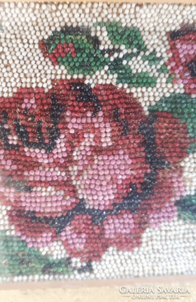 A goblein wall mural with roses made of beads