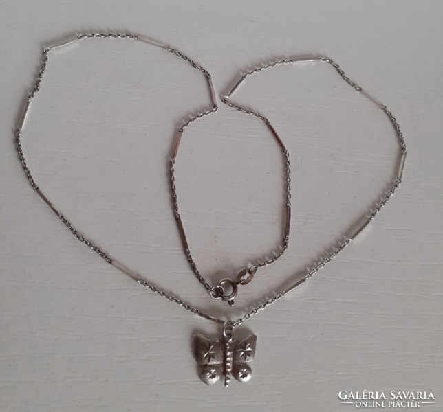 A marked silver necklace with a stamped silver butterfly pendant in good condition