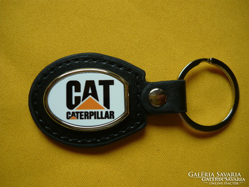 Cat caterpillar metal keychain on a leather background