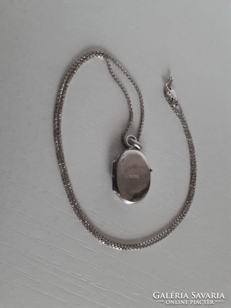 A marked silver necklace in good condition with a marked chiselled silver openable heart pendant