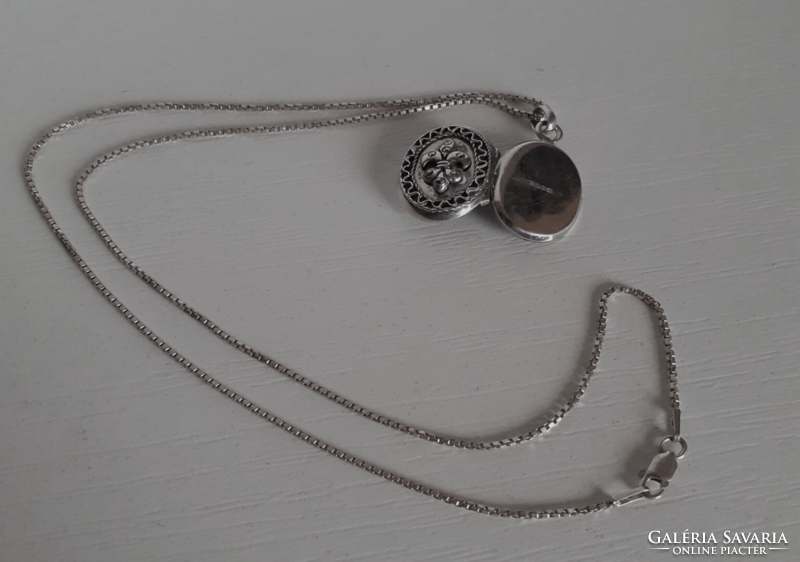 A marked silver necklace in good condition with a marked chiselled silver openable heart pendant