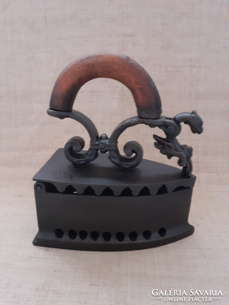 An old charcoal cast iron iron depicting a phoenix bird with a grate inside