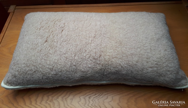 Small pillow filled with wool, with a wool cover
