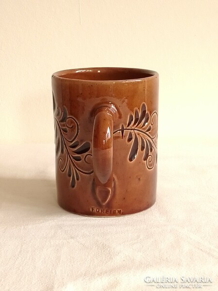 Old brown ceramic mug marked foreign, with a flower pattern printed on the material