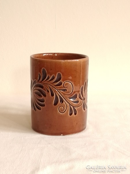 Old brown ceramic mug marked foreign, with a flower pattern printed on the material