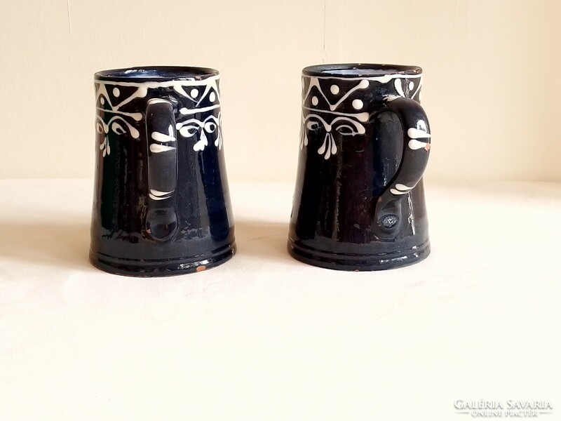 Two ceramic pitcher mugs with a white pattern on an old cobalt blue glazed base
