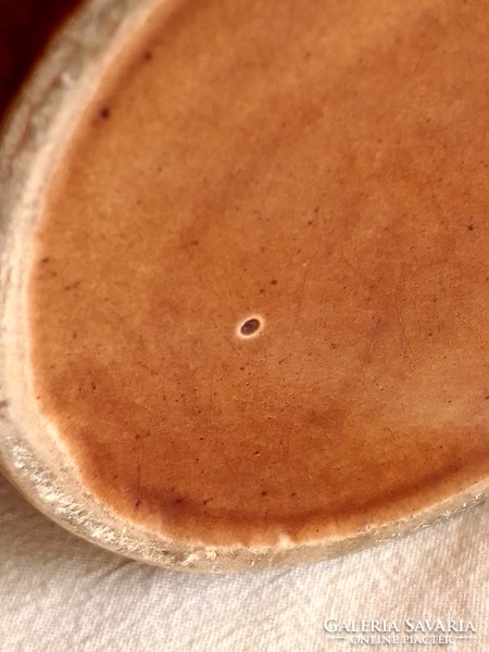 Old brown ceramic mug marked foreign, with a flower pattern printed on the material