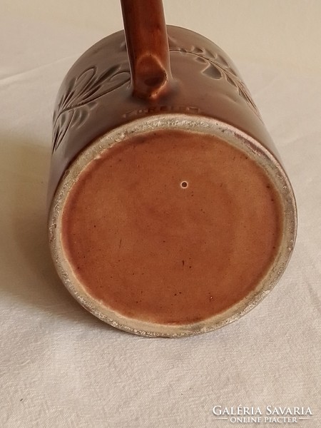 Old brown ceramic mug marked foreign, with a flower pattern printed on the material