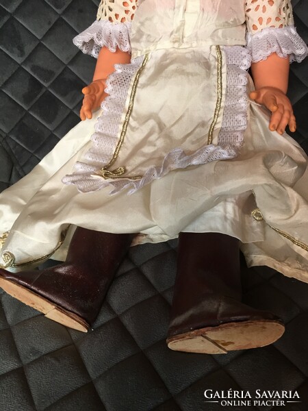 Little girl in old, retro Hungarian, palatial dress with doll party, in boots