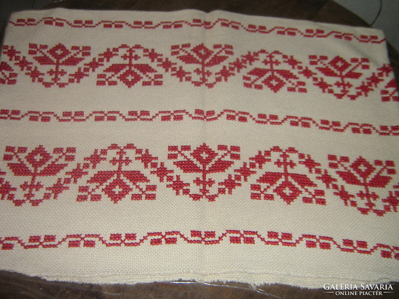 Beautiful hand-embroidered throw pillow sewn with red cross stitch
