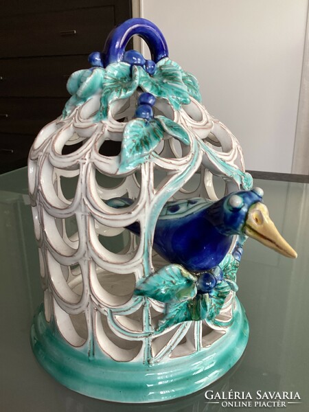 Zsuzsa Morvay's bird sitting in a cage in the iconic blue-green shade, openwork ceramic surface.
