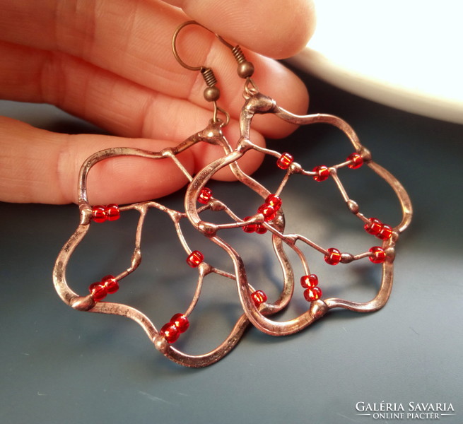 Swirling red pearl earrings soldered into a copper wire frame