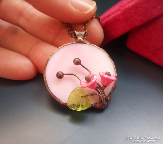 Handcrafted glass jewelry with a bouquet of flowers on pink glass