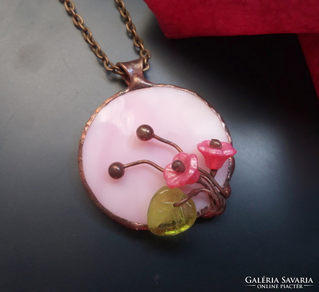 Handcrafted glass jewelry with a bouquet of flowers on pink glass