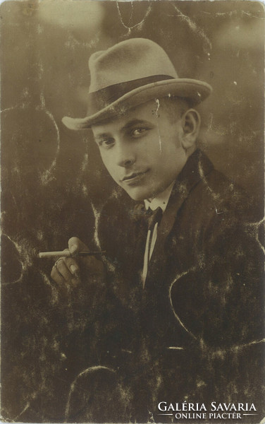 Elegant, wealthy young man in a hat with a cigarette. Studio recording, photo sheet. 1920s, 1930s