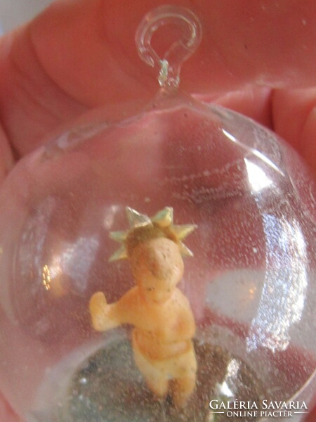 A small wax Jesus Christmas tree ornament in a sphere