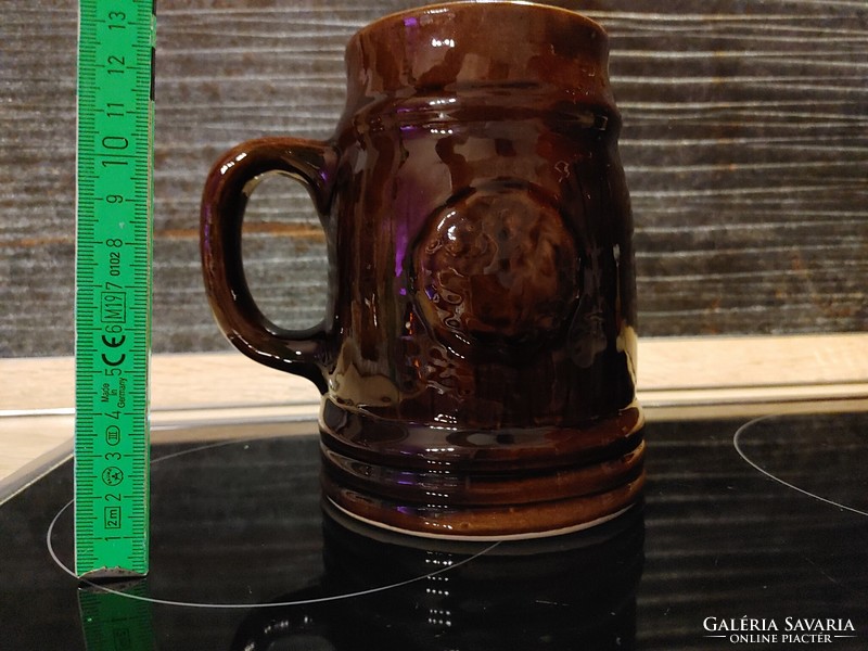 Two ceramic beer mugs, one with a green leaf frog