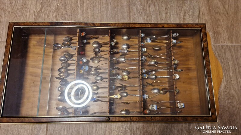 61 decorative spoons in a glass holder.