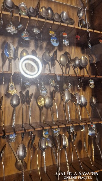 61 decorative spoons in a glass holder.