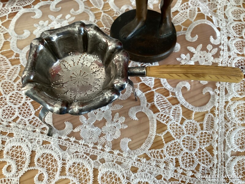 Antique silver tea strainer with bone tongs.
