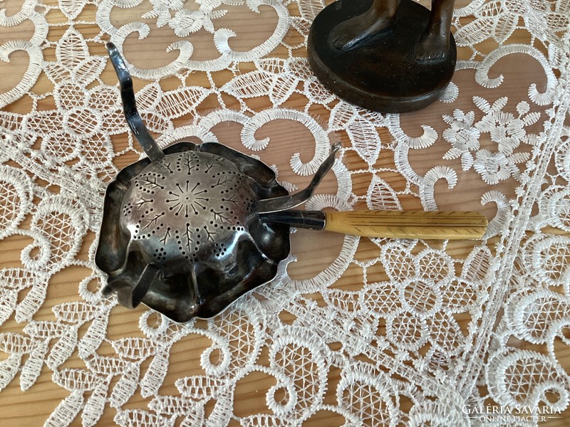 Antique silver tea strainer with bone tongs.