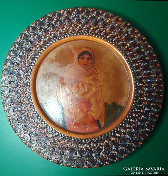An old folk wooden plate decorated with a hand-painted portrait that can be hung on the wall