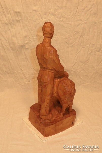 Carved statue of a man with a goat. Indicated.