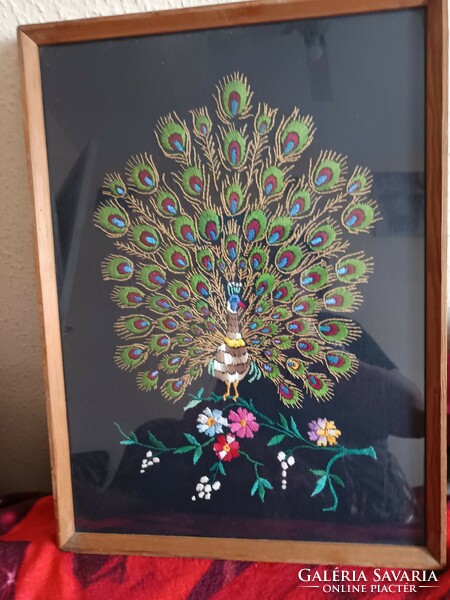 Embroidered wall picture with a peacock motif in a glazed frame