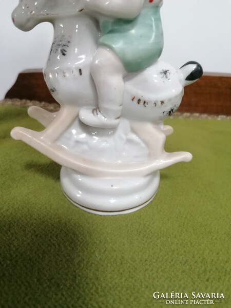 Zhk Russian porcelain toddler with a rocking horse, the horse's ears are damaged