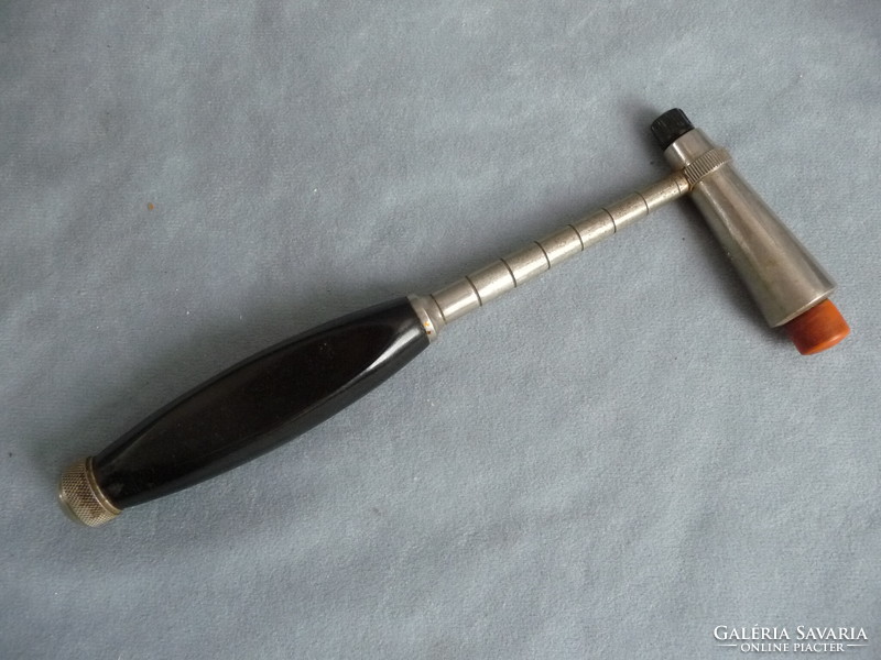 Old medical device neurological reflex hammer from the 1940s with a vinyl handle and a screw-out needle