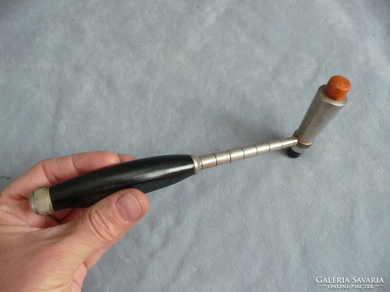 Old medical device neurological reflex hammer from the 1940s with a vinyl handle and a screw-out needle