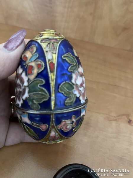 Fairy large fire enamel openable egg with three-legged wooden holder.