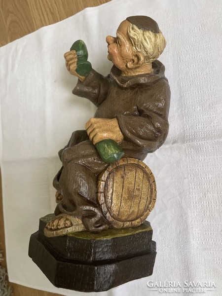 Cheerful, funny, carved wooden statue of a drunken monk.