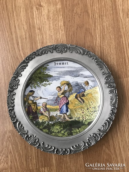 Beautiful tin-rimmed porcelain inlaid plate hanging on the wall