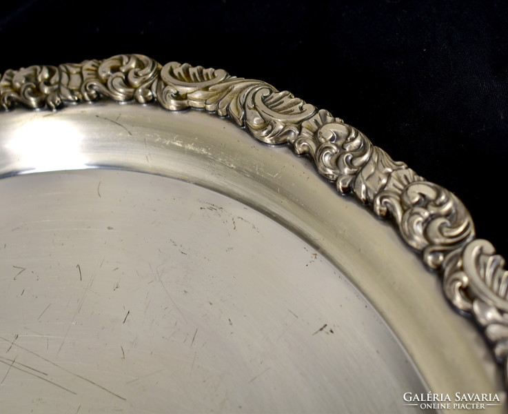 A large round tray silver-plated with a rich relief pattern