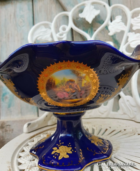 A beautiful cobalt blue serving bowl with a stand on the outside and inside