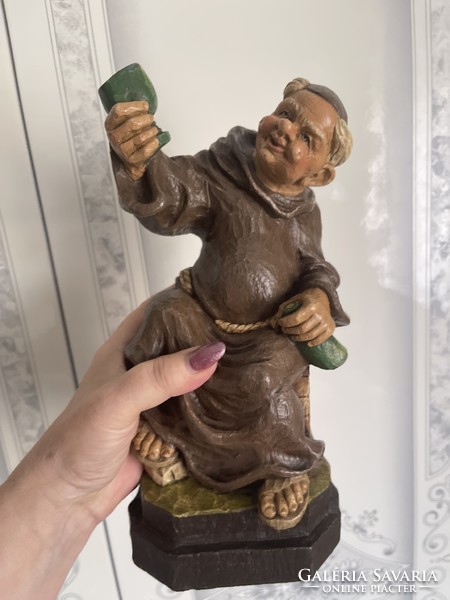 Cheerful, funny, carved wooden statue of a drunken monk.