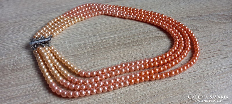 Peach-colored four-row string of pearls, neck blue