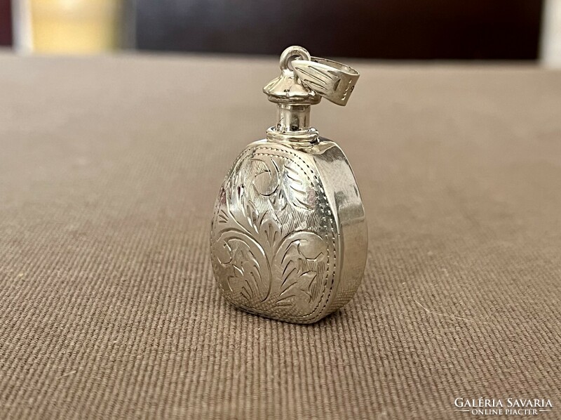 Silver pendant holding cologne