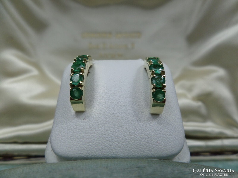 Gold stud earrings with a pair of emeralds