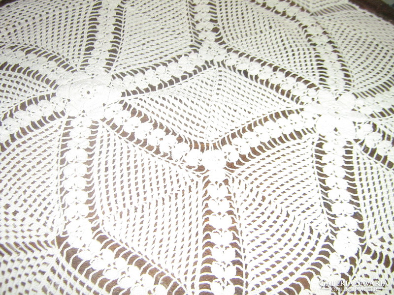 Beautiful white hand-crocheted tablecloth with a special shape of flowers