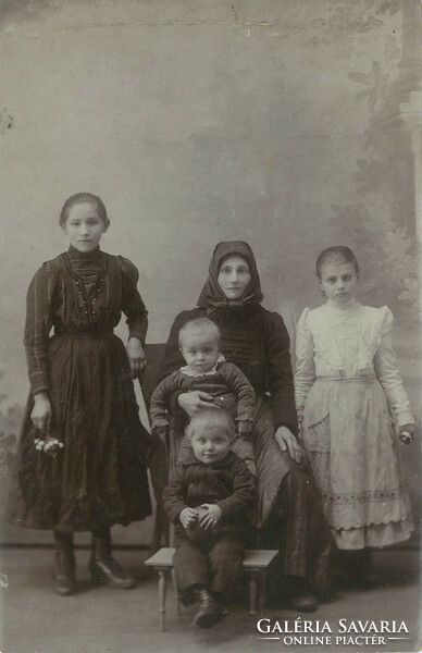 Early 1900s. Young mother with children, studio shot. Its maker is unknown.