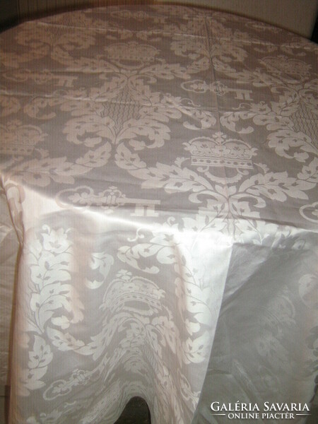 Beautiful shiny baroque pattern on elegant shiny snow-white silk tablecloth