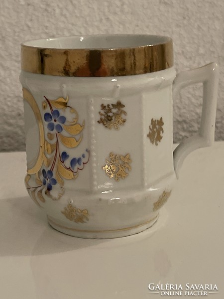 Porcelain mug with antique embossed pattern, richly gilded..