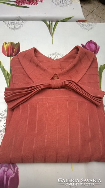 A really feminine coral-colored blouse with a bow, buttons all the way at the back - even for an occasion!