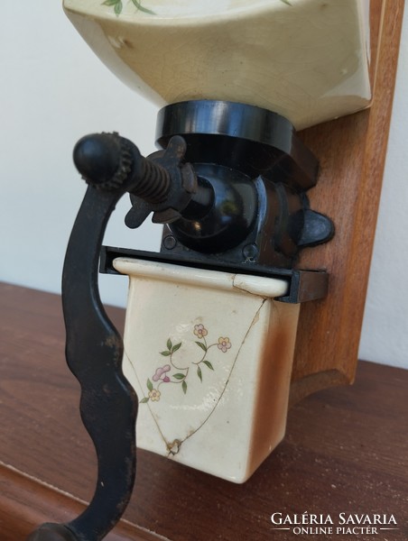 A wall-mounted coffee grinder with a nice solid decor and a ceramic body