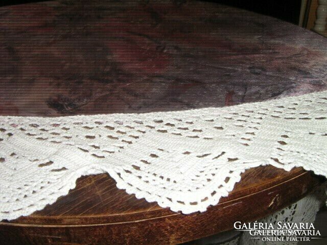 A round tablecloth with a hand-crocheted edge in a beautiful color scheme