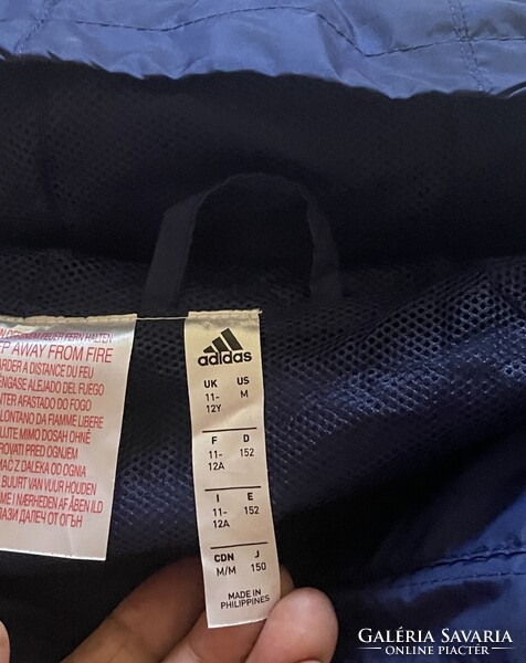 Adidas Core gyerek / széldzseki sötétkék (navy blue) szinben, fehér díszitöcsíkokkal.