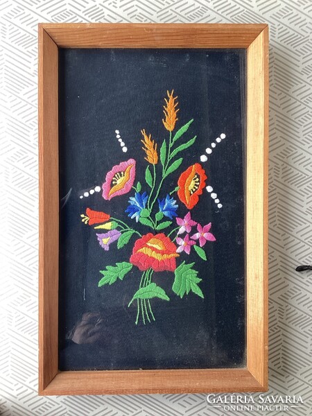 Hímzett  falikép , üvegezett keretben .